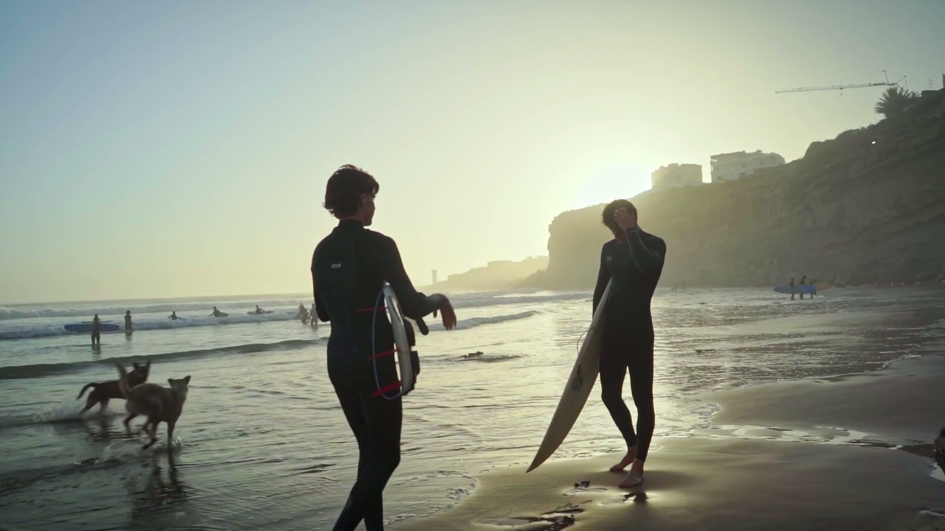 Surfers at golden hour on a Devon beach, from Shore Break Media footage